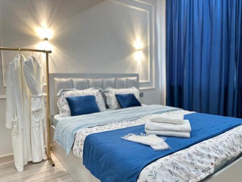 a bedroom with a blue bed with towels on it at Gala group in Akchiy