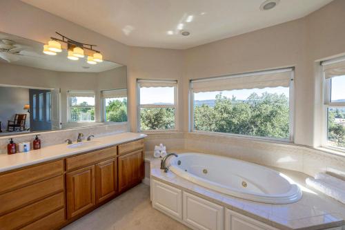 Un baño con bañera grande y dos ventanas. en Hemlock Hacienda, en Groveland