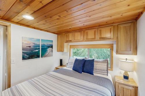a bedroom in a tiny house with a bed and a window at Whaleshead Getaway in Carpenterville