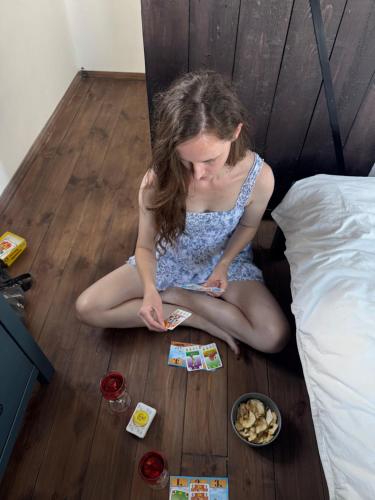 a young woman sitting on the floor playing cards at Söréttorony - A jakuzzis erdei szállás in Kölesd