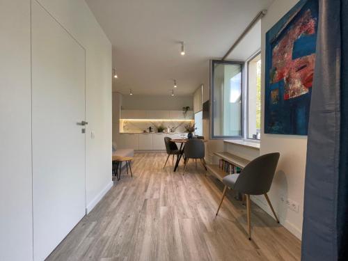 a living room with a table and chairs and a kitchen at Apartment Parko in Molėtai