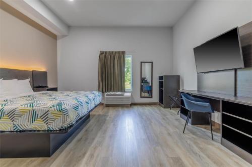 a hotel room with a bed and a desk at Studio 6 Gonzales, LA Baton Rouge Geismar Prairieville I 10 in Gonzales