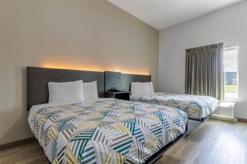 a hotel room with two beds and a window at Studio 6 Gonzales, LA Baton Rouge Geismar Prairieville I 10 in Gonzales