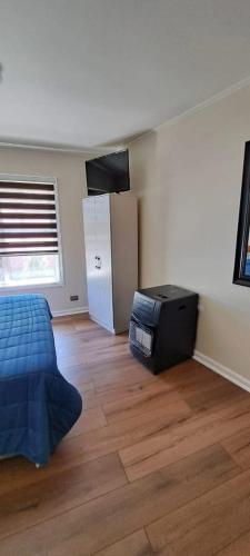 オソルノにあるDepartamento full equipado con 1 habitación matrimonialのベッドと木の床のある寝室