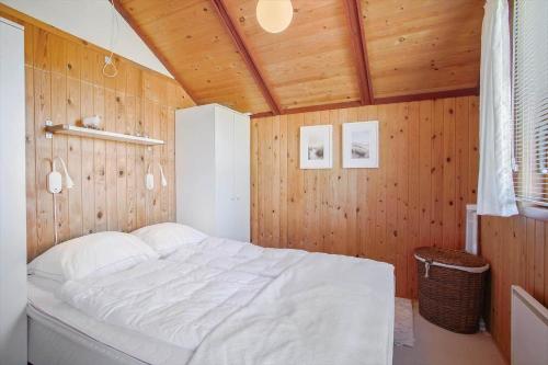 a bedroom with a white bed in a wooden wall at 1024-Thisted-Lars-Badskjaers-Sti-2 in Torsted