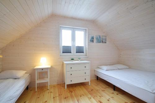 En eller flere senge i et værelse på Baltic Domki