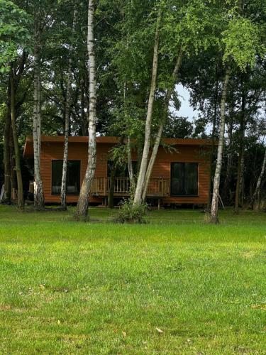 a log cabin in the middle of a field with trees at Holiday House Nature in Lier