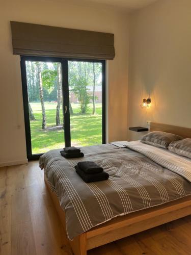 a bedroom with a large bed with a large window at Holiday House Nature in Lier