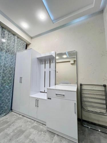 a kitchen with white cabinets and a mirror at AZ Villa in Gabala in Gabala