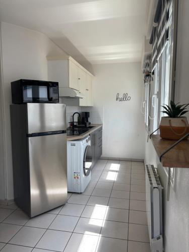 une cuisine avec un réfrigérateur en acier inoxydable dans l'établissement Grand appartement à 3mn de la plage, à Saint-Nazaire