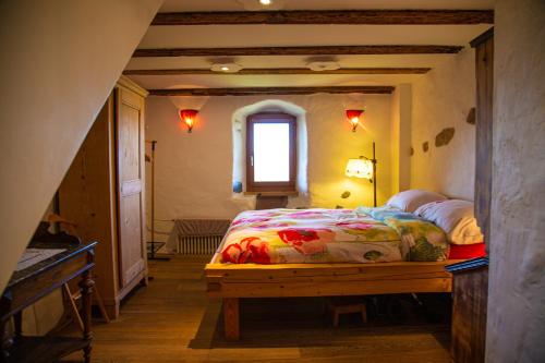 a bedroom with a bed and a window at Au soleil de Gruyères chez Chantal in Gruyères
