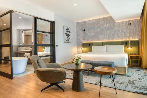 a hotel room with a bed and a table and chairs at Hotel Indigo Lima Miraflores by IHG in Lima