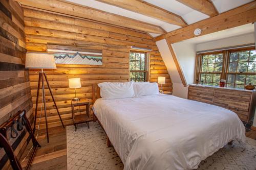 a bedroom with a large bed in a room with wooden walls at Little Bear Cabin By Hauserman Rentals in Tahoe Vista