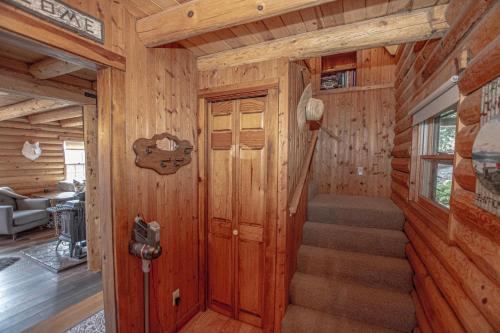 a room with a staircase in a cabin with wooden walls at Little Bear Cabin By Hauserman Rentals in Tahoe Vista