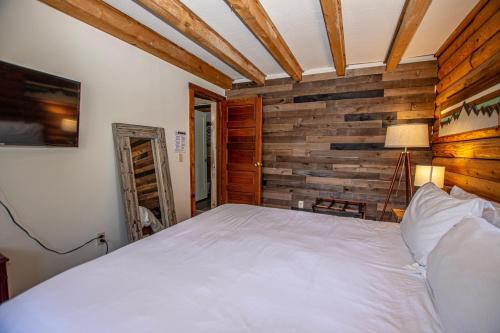 a bedroom with a bed and a wooden wall at Little Bear Cabin By Hauserman Rentals in Tahoe Vista