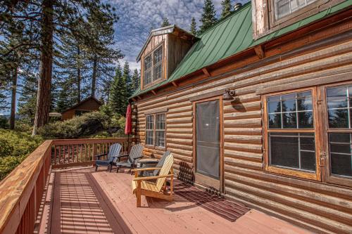 a wooden cabin with two chairs on a deck at Little Bear Cabin By Hauserman Rentals in Tahoe Vista