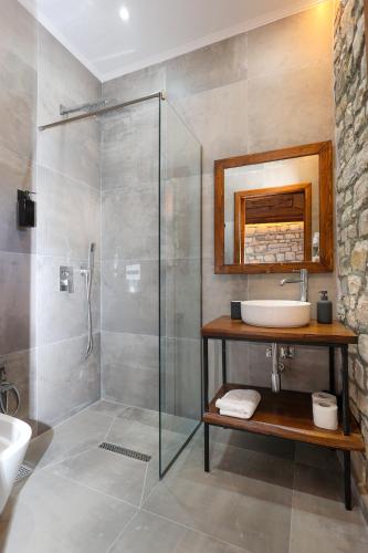 a bathroom with a glass shower and a sink at Oda e Gurit - Boutique Hotel in Berat