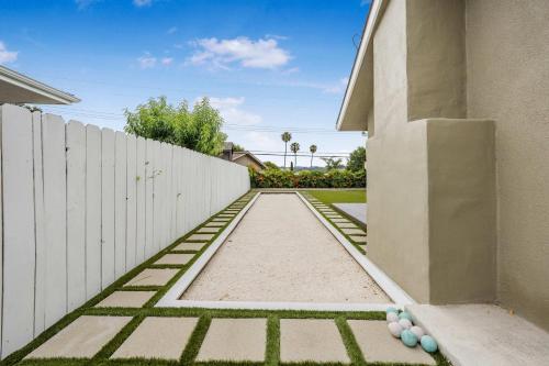 a backyard with a white fence and a sidewalk at Sleeps 11 Wine Trail Fire Pit Bocce & Trampoline in San Luis Obispo