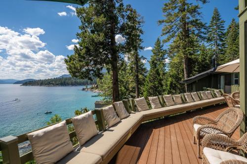 a row of chairs sitting on a deck overlooking a lake at McCown Lakefront By Hauserman Rentals in Tahoma