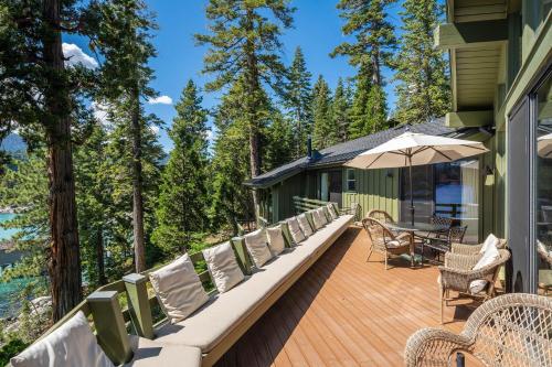 a deck with chairs and an umbrella on a house at McCown Lakefront By Hauserman Rentals in Tahoma