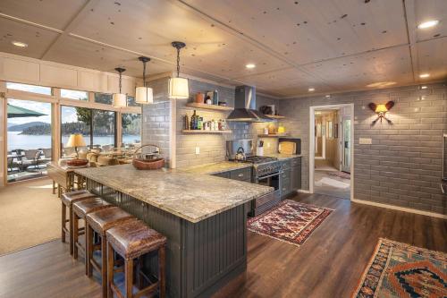 a kitchen with a large island with bar stools at McCown Lakefront By Hauserman Rentals in Tahoma