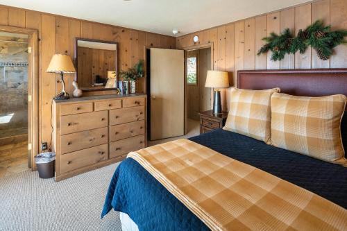 a bedroom with a bed and a dresser and a mirror at McCown Lakefront By Hauserman Rentals in Tahoma