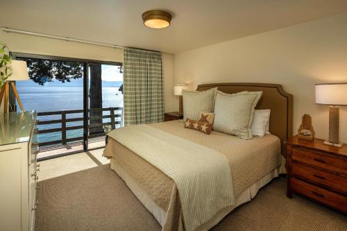 a bedroom with a bed with a view of the ocean at McCown Lakefront By Hauserman Rentals in Tahoma