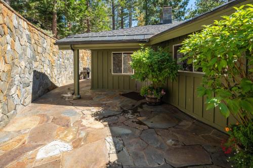 a small green shed with a stone wall at McCown Lakefront By Hauserman Rentals in Tahoma