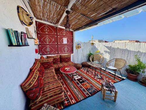 einen Balkon mit einem Bett, einem Tisch und Stühlen in der Unterkunft Dar Oussama in Rabat