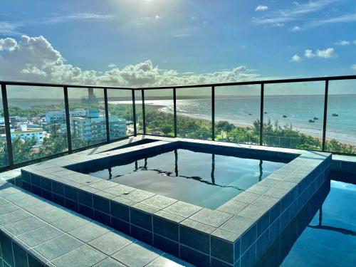 a swimming pool on top of a building with the beach at DVA Cabedelo Beira-Mar – O Paraíso na Ponta de Cabedelo in Cabedelo