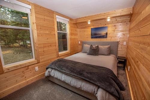 a bedroom with a bed in a wooden cabin at O'Brien's Den By Hauserman Rentals in Tahoma