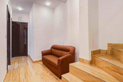 a brown chair sitting in a room with stairs at Super HOTEL O CK INN in Charbagh