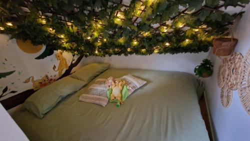 eine Frau, die auf einem Bett liegt, auf dem ein Baum steht in der Unterkunft Maison 15 minutes de Disney le refuge des contes Parking gratuit Wifi in Mareuil-lès-Meaux