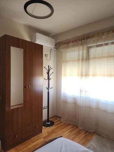 a bedroom with a window with a plant on the wall at Feel like home 1 in Shkodër