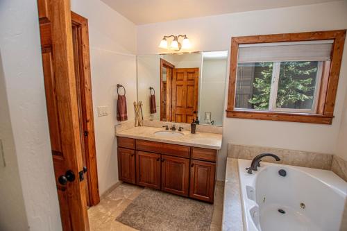 a bathroom with a tub and a sink and a mirror at Tahoe Haven By Hauserman Rentals in Carnelian Bay