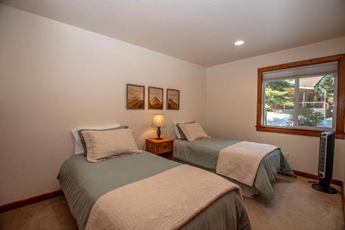 a bedroom with two beds and a window at Tahoe Haven By Hauserman Rentals in Carnelian Bay