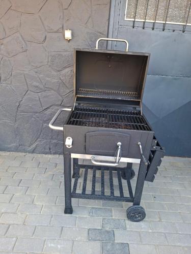 a barbecue grill sitting on a brick patio at Gyöngyvirág Apartmanház in Zalakaros