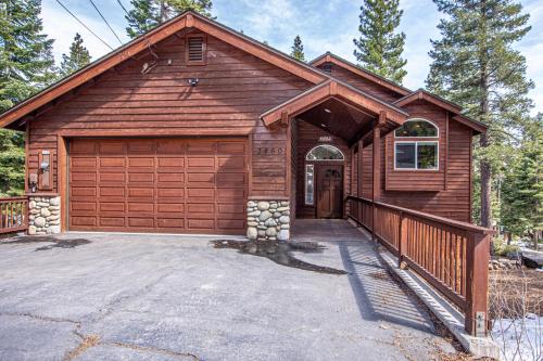 a house with a wooden garage with a driveway at Tahoe Haven By Hauserman Rentals in Carnelian Bay