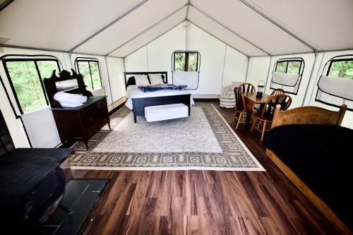 a room with a bed and a table in a tent at Growing Faith Farms & Retreat in Moravian Falls