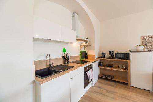 a kitchen with white cabinets and a sink at Appartement avec veranda et 3 chambres Guingamp in Guingamp