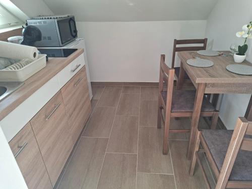 a kitchen with a table and a dining room at Gyöngyvirág Apartmanház in Zalakaros