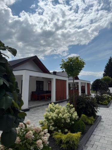a house with a garden in front of it at Zator Domki Dreampark in Zator