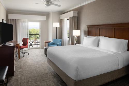 a hotel room with a bed and a desk and a television at Holiday Inn Resort Lake George by IHG in Lake George
