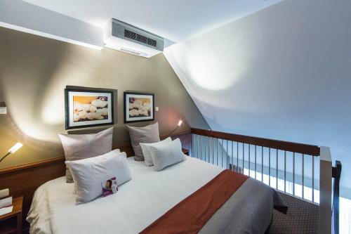 a bedroom with a large bed with white pillows at Crowne Plaza Maastricht by IHG in Maastricht