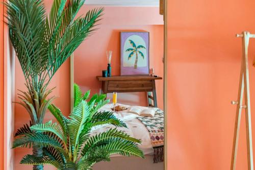 a bedroom with orange walls and a bed with a plant at Palm Royal in Breda