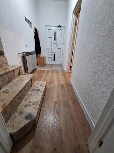 a hallway with wooden floors and a white door at Vikendica Ivan Blidinje in Blidinje