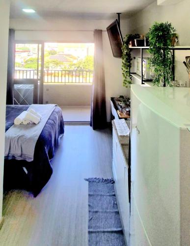 a bedroom with a bed and a balcony at Studio Metrô Tatuapé Wi-fi-Piscina-Academia in Sao Paulo