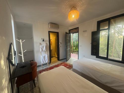 a bedroom with two beds and a yellow door at Ecolodge Dar bouhouta in Tahannout