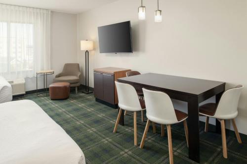 a hotel room with a dining room table and chairs at TownePlace Suites by Marriott Billings in Billings