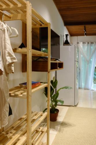 a wooden shelf in a kitchen with a refrigerator at Pituba Ville - Ap Floresta in Itacaré